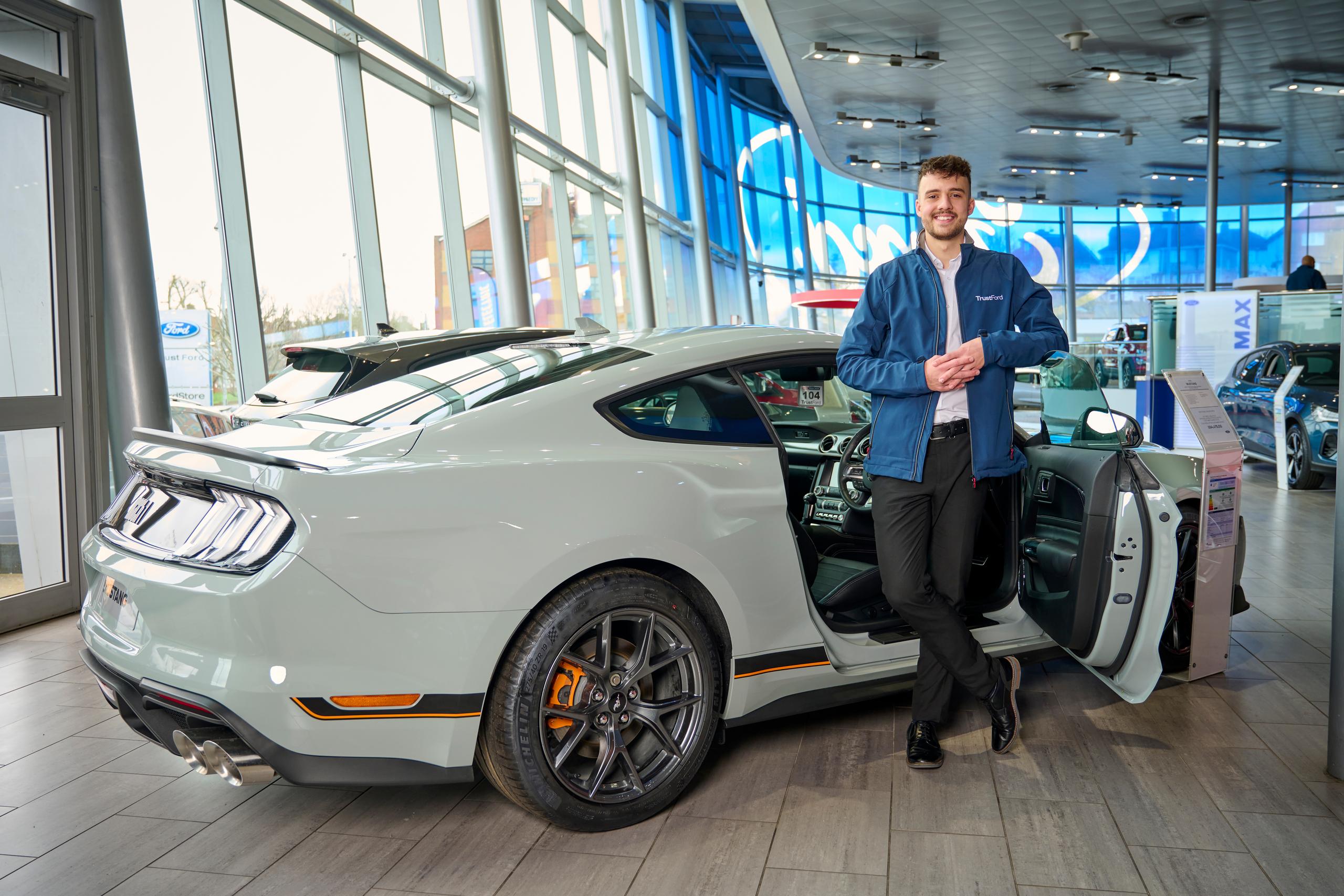 Man stood with a new ford sportscar