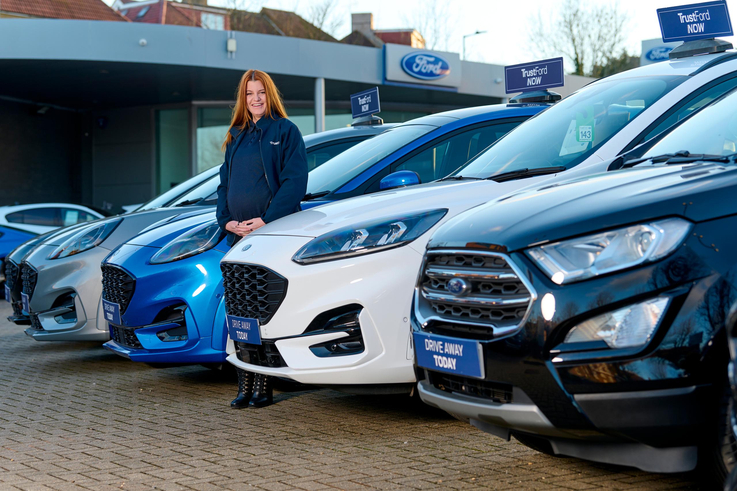 Woman stood infront of ford cars